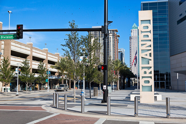 A street corner in downtown Orlando, Florida. There is a large vertical sign that says Orlando on the corner.