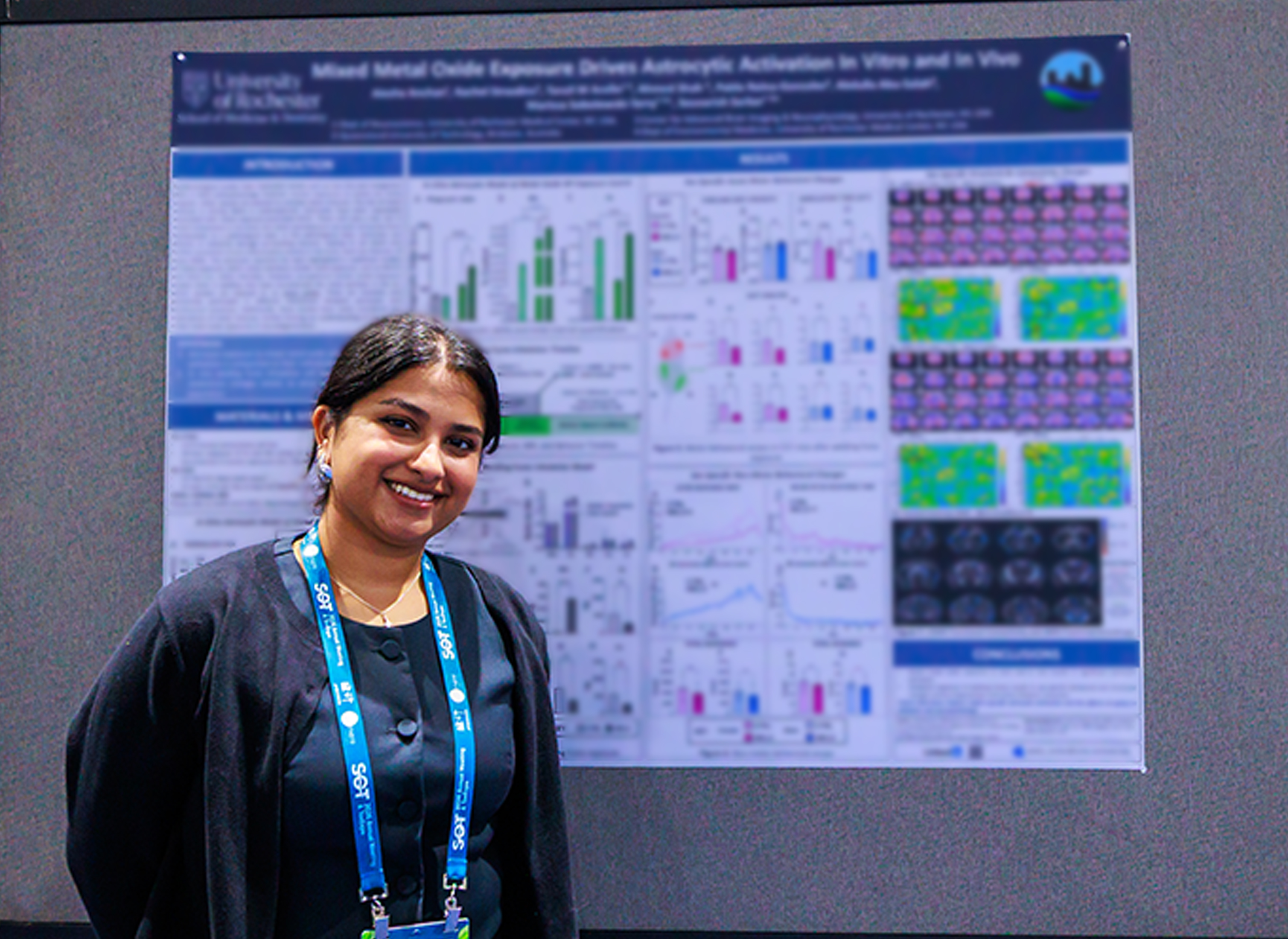 An SOT Annual Meeting attendee stands in front of a research poster displayed in the ToxExpo hall. 