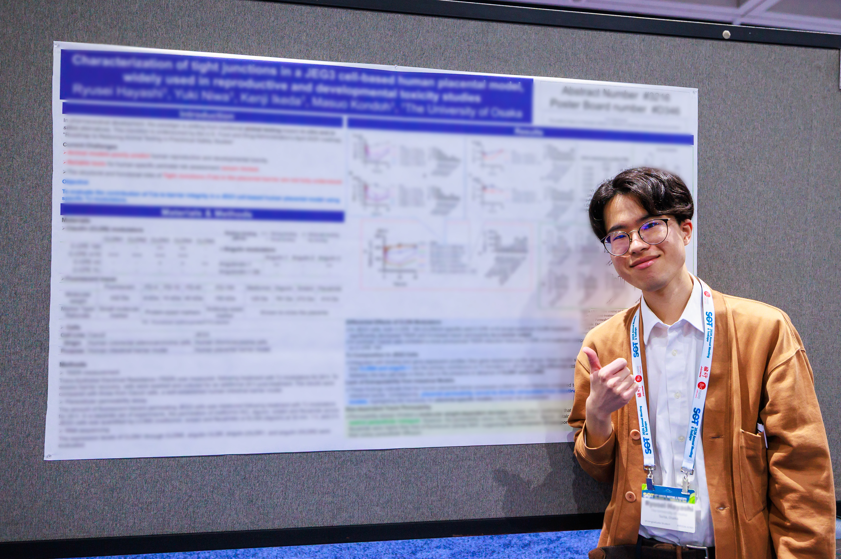 An SOT Annual Meeting attendee stands in front of a research poster displayed in the ToxExpo hall. 