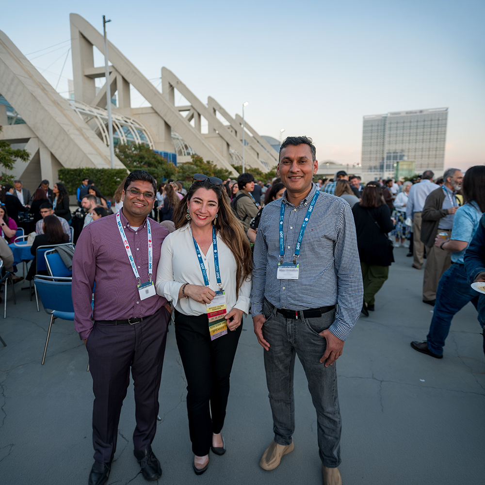 Three SOT Annual Meeting attendees smile for a photo the convention center.