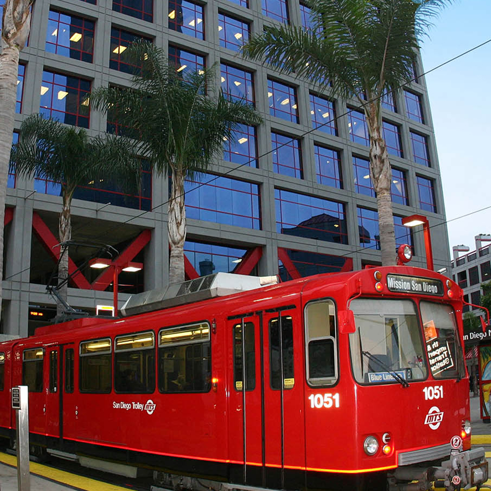 A bright red train is sitting at a train stop.