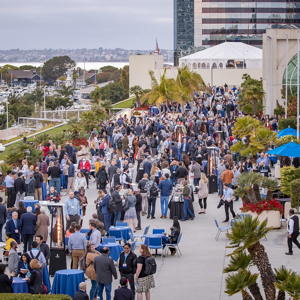 A reception is taking place on an outdoor terrace. A marina is visible in the background.