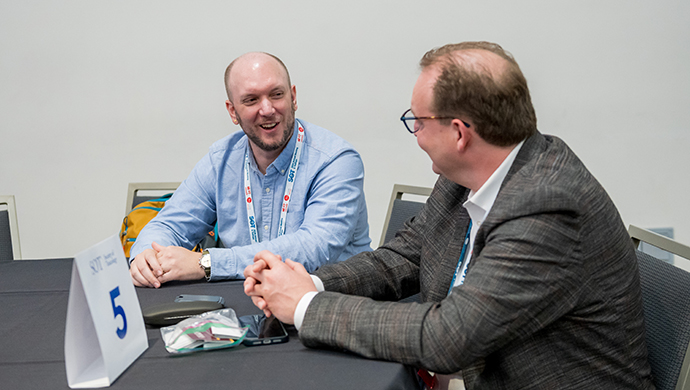 Two SOT Annual Meeting attendees sit at a table and talk.  