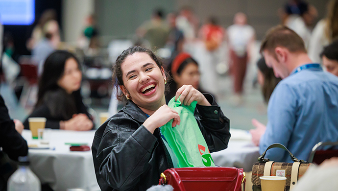 An SOT Annual Meeting attendee laughs while holding a green SOT shirt. 