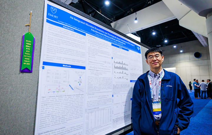 An SOT Annual Meeting attendee stands beside his poster in the ToxExpo hall. 