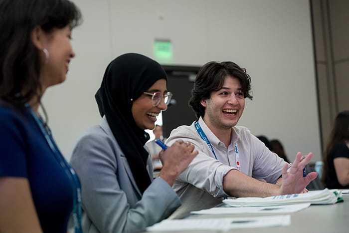 Three SOT Annual Meeting attendees laugh and talk during a small group discussion. 