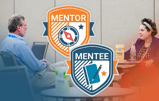 Two attendees sit at a small table in the SOT Mentorship Lounge, talking in a conference room.