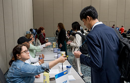 A volunteer scans an attendee badge at a check-in table.